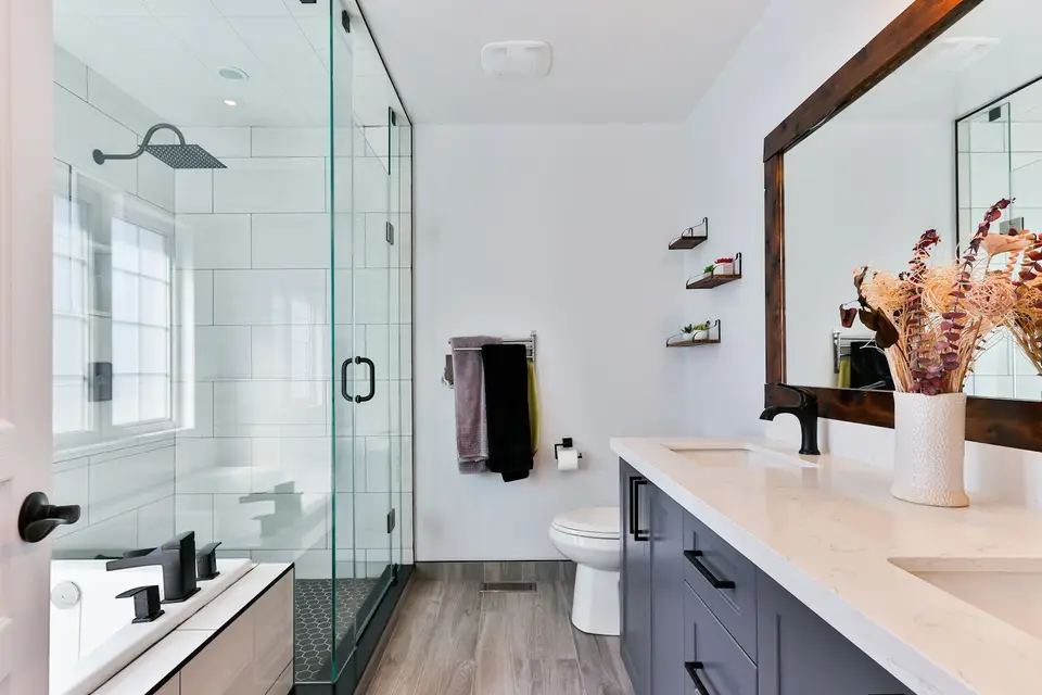 Remodeled bathroom with a tiled walk-in shower, glass door and new vanity