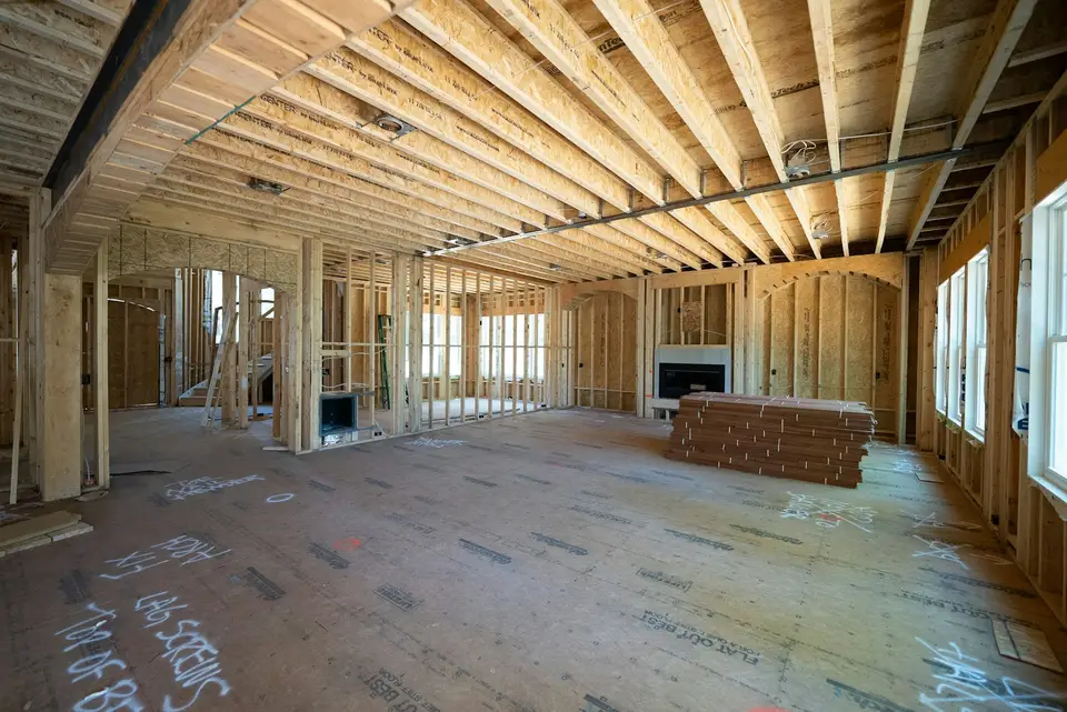 Framing crew building a wood-framed home addition with new window openings