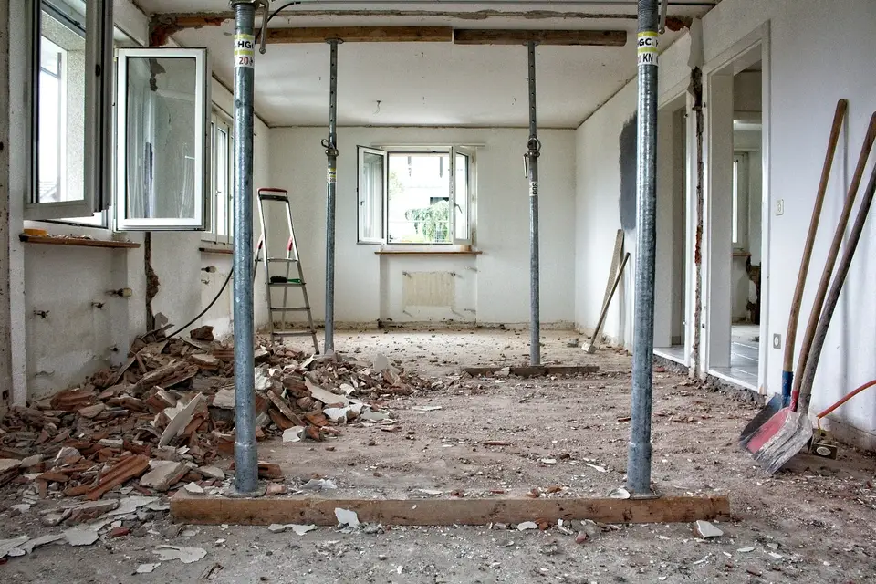 Gutted kitchen with plastic dust containment walls and floor protection during interior demolition — Framingham, MA