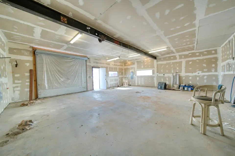 Finisher applying a skim coat of joint compound to a drywall wall with a wide knife