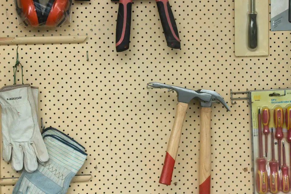 Handyman patching a drywall hole with a putty knife before painting