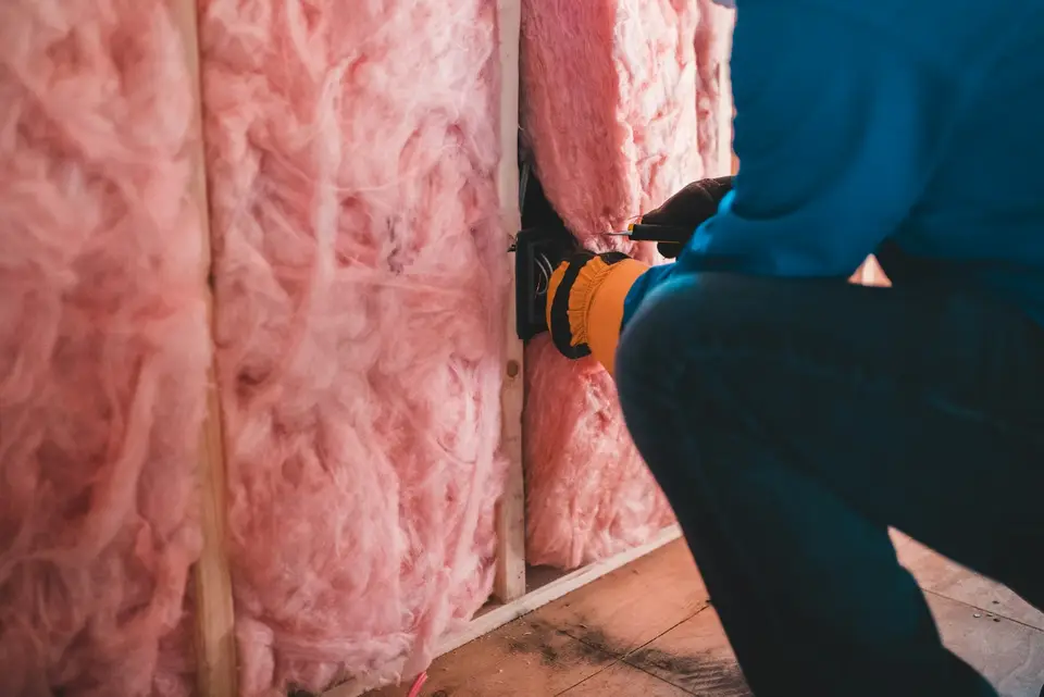 Blown-in cellulose insulation covering attic floor joists with ventilation baffles at the eaves — Ashland, MA
